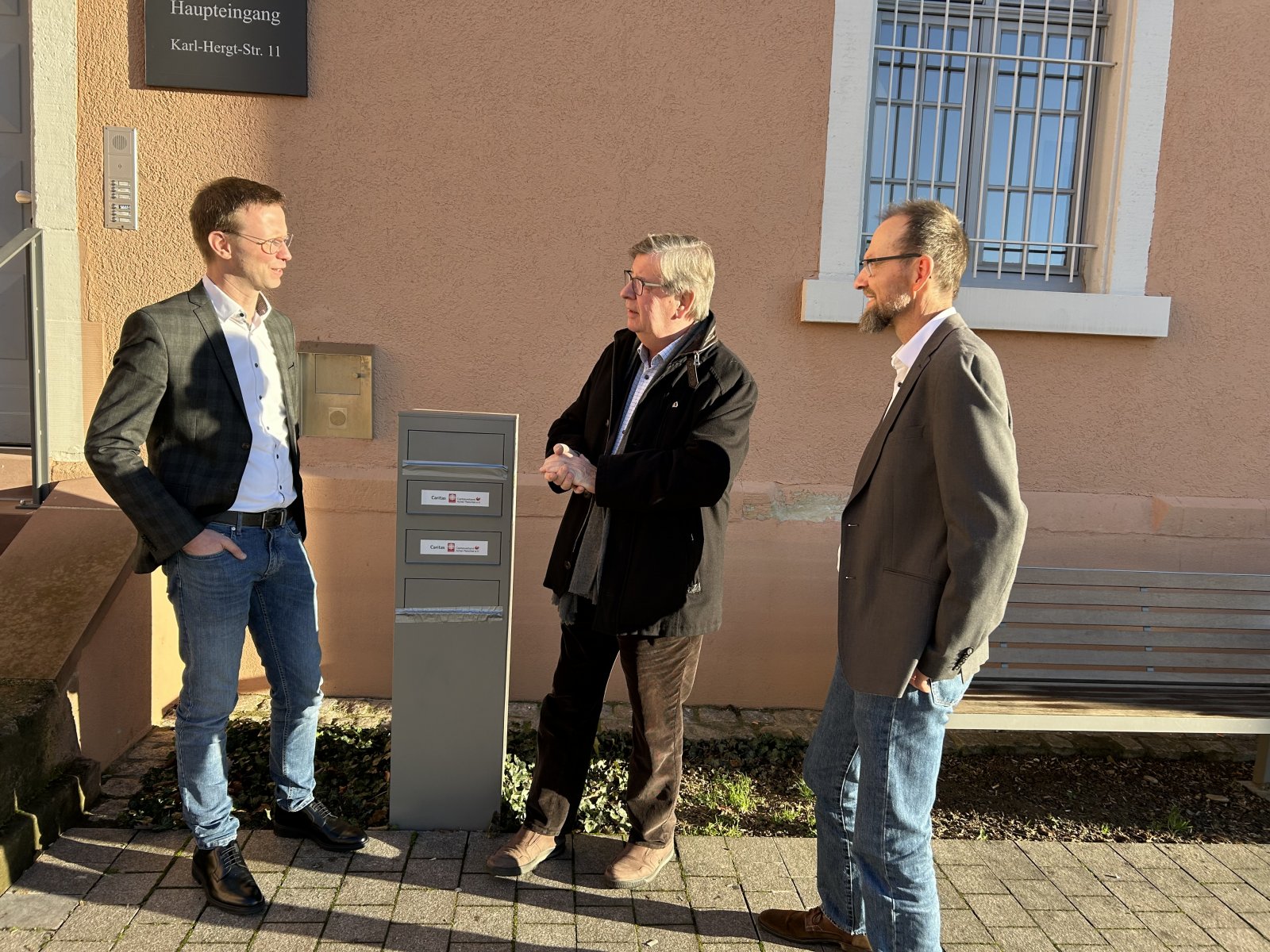 Vorstand Kai Möschle, Abgeordneter Willi Stächele und Vorstand Robert Sauer vor dem Gebäude der Caritas in Achern.  